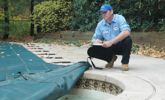 Photo of a Jayson Pool Technician inspecting an in-ground pool