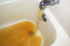 photo of badly discolored water from iron deposits and sediment in water pipes